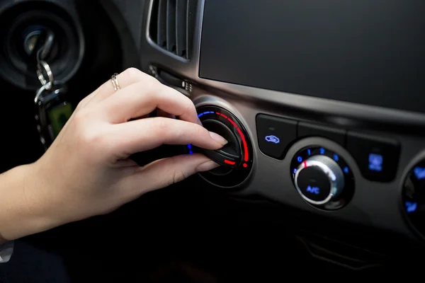 Frau stellt Temperatur der Klimaanlage im Auto ein — Stockfoto