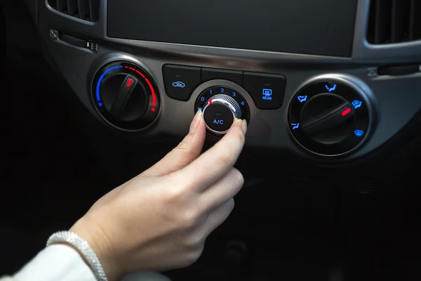 Woman turning on car air conditioning — Stock Photo, Image