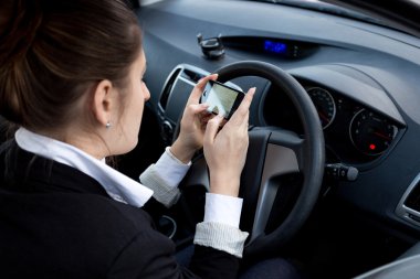Araba sürerken Smartphone kullanarak iş kadını
