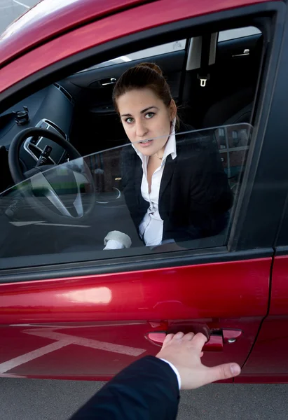 Ladrón irrumpiendo en el coche. Mujer asustada bloqueando la puerta —  Fotos de Stock