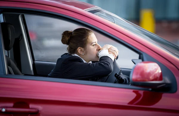 Втомилася жінка за кермом автомобіля і дивиться через вікно — стокове фото