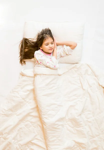 ベッドで寝ているかわいい女の子の上部から分離された写真 — ストック写真