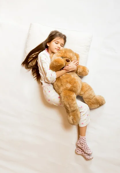 Foto aislada de linda chica durmiendo abrazando oso de peluche —  Fotos de Stock