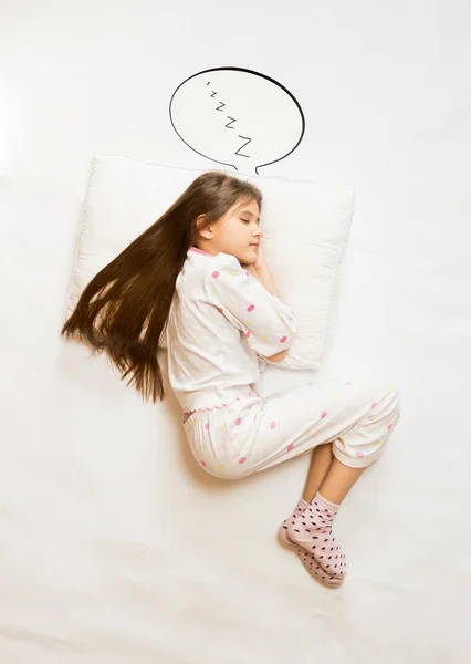 Søt jente som sover på en stor pute med taleboble – stockfoto