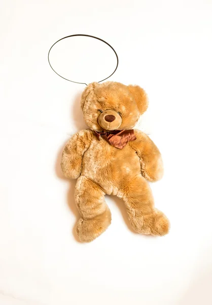 Cute teddy bear with copyspace speech bubble lying on floor — Stock Photo, Image