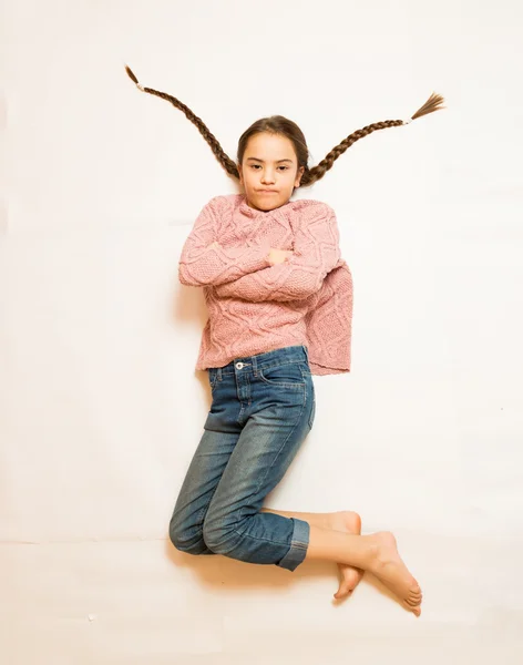 Isoliertes Foto eines traurigen Mädchens mit langen Zöpfen auf dem Boden liegend — Stockfoto