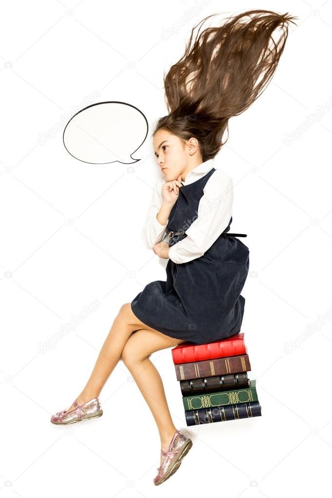 Isolated shot of thoughtful schoolgirl sitting on pile of books