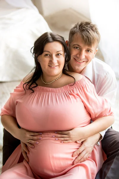 Retrato de homem bonito abraçando esposa grávida de costas — Fotografia de Stock