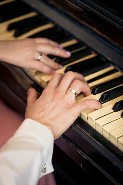 Getöntes Foto des frisch verheirateten Paares beim Klavierspielen — Stockfoto