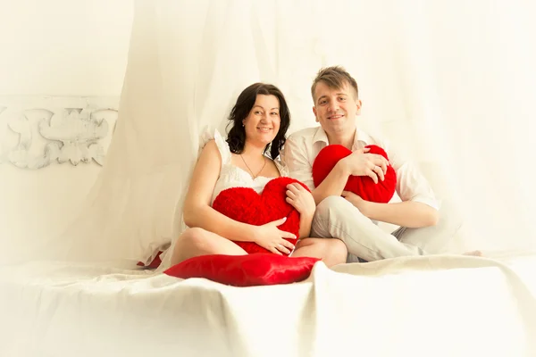 Toned foto de casal grávida posando em cama grande com careca — Fotografia de Stock