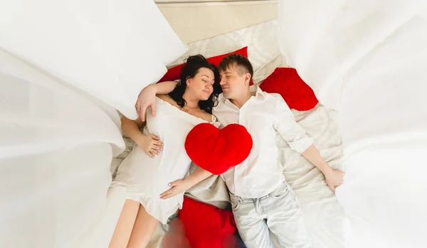 Mutlu hamile çift yatakta yatarken üstünden görüntülemek — Stok fotoğraf