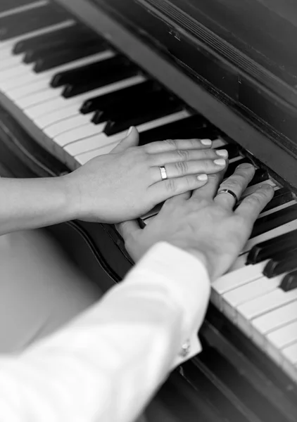Black and white photo of bride and groom playing on piano Royalty Free Stock Images