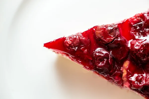 Closeup of cherry cheesecake on white dish — Stock Photo, Image