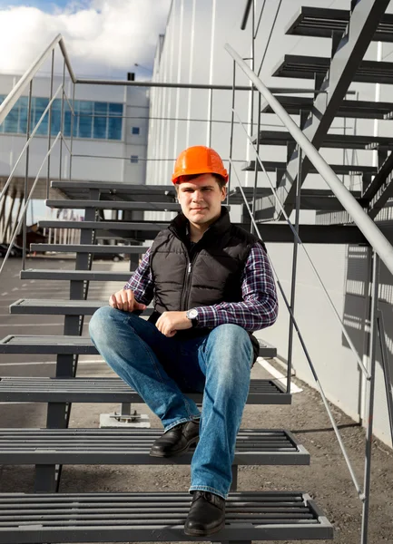 Smiling worker relaxing on metal staircase during break — Stock Photo, Image