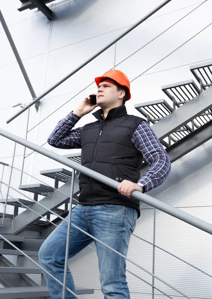 Arkitekten prata telefon samtidigt inspektera fabriken — Stockfoto