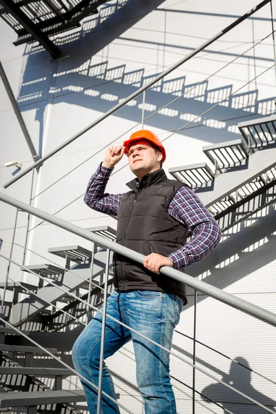 Manliga arbetstagare i hardhat står på stål trappa — Stockfoto