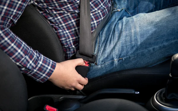 Foto de close-up do homem sentado no assento do motorista e cinto de fixação — Fotografia de Stock