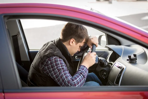 Erschöpfter junger Mann schläft während Autofahrt auf Fahrersitz — Stockfoto