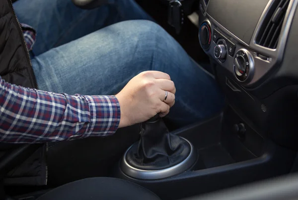 Closeup of young man shifting manual gearbox in car — Stock Photo, Image