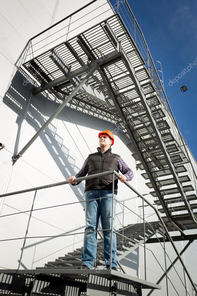 Building control inspector standing on metal staircase