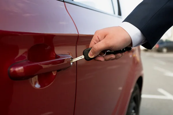 Närbild skott av affärsman öppna parkerad bil med nyckel — Stockfoto