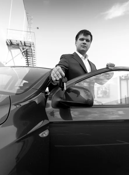 Black and white portrait businessman showing car key — Stock Photo, Image