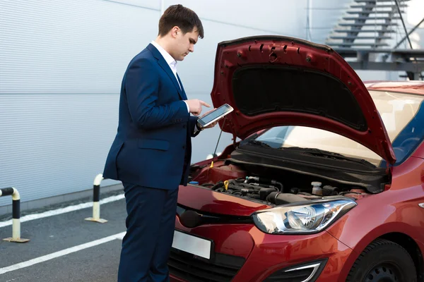 Sales manager making photo under car bonnet — Stock Photo, Image