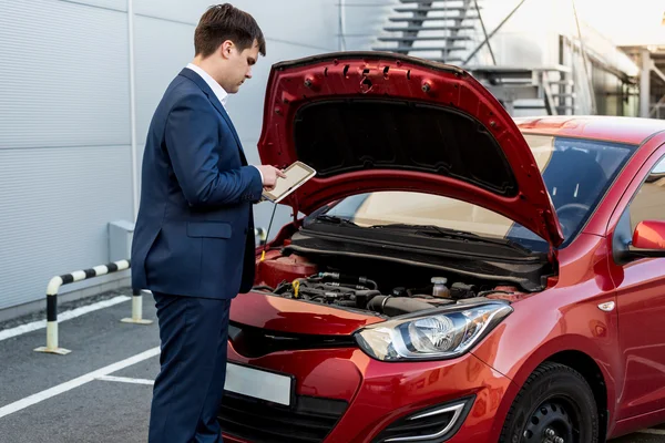 Manager checking car condition on tablet — Stock Photo, Image