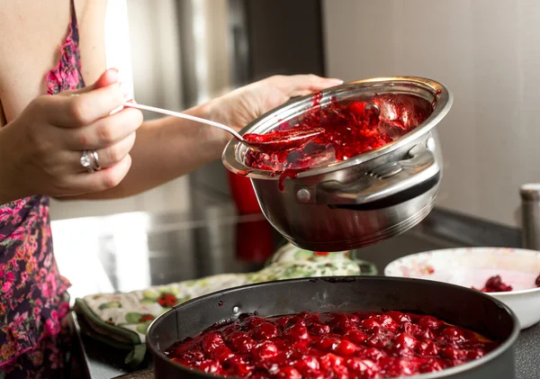 Femme au foyer faisant de la confiture de cerises dans une casserole en métal — Photo