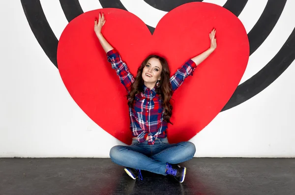 Concept photo of happy woman sitting on floor with big red heart — Stock Photo, Image