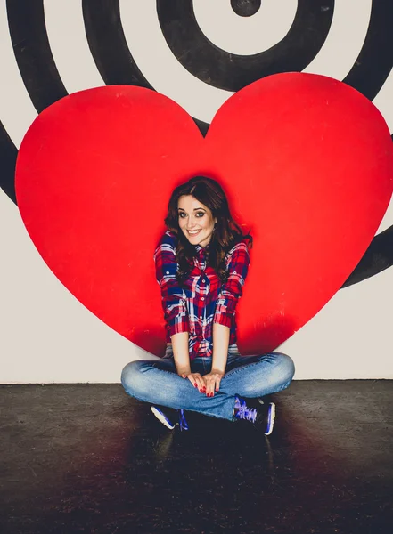 Toned photo of woman posing at studio with big red heart — Stock Photo, Image