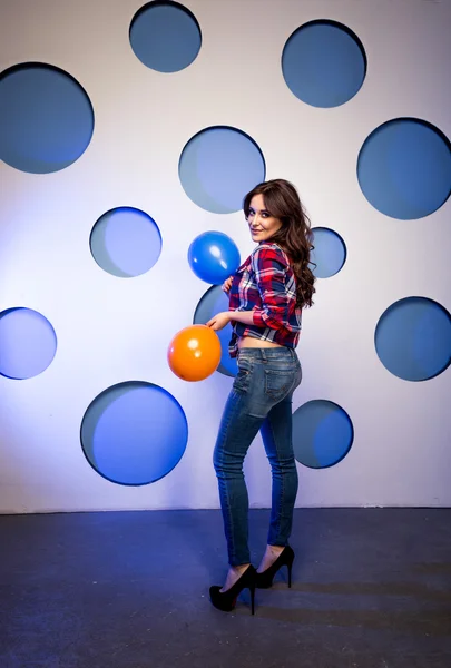 Mulher sorrindo posando com balões contra fundo colorido — Fotografia de Stock