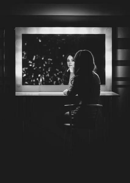 Black and white photo of woman posing in dressing room at mirror — Stock Photo, Image