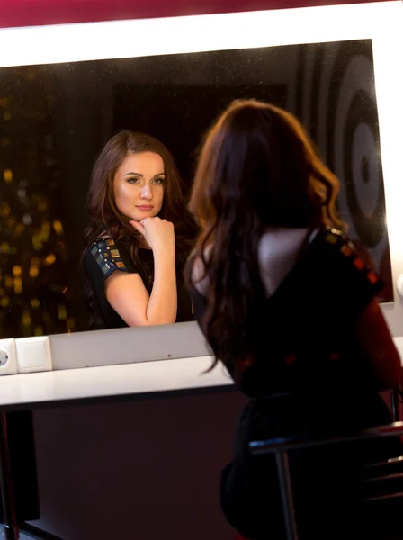 在黑暗的房间里，在镜子摆姿势的性感黑发女人 — 图库照片