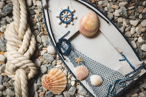 Moldura decorada por conchas e cordas deitadas sobre pedras na costa — Fotografia de Stock