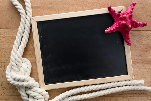 Toned photo of empty blackboard with starfish and marine knot — Stock Photo, Image