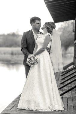 Gelin ve damat iskelede nehir poz siyah ve beyaz çekim