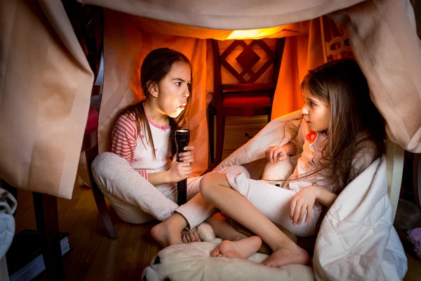 Elder sister telling scary story to younger one at late night — Stock Photo, Image