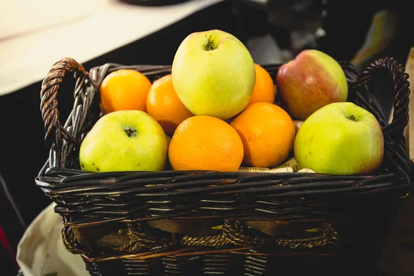 Getönter Schuss Korb voller Orangen und grüner Äpfel — Stockfoto