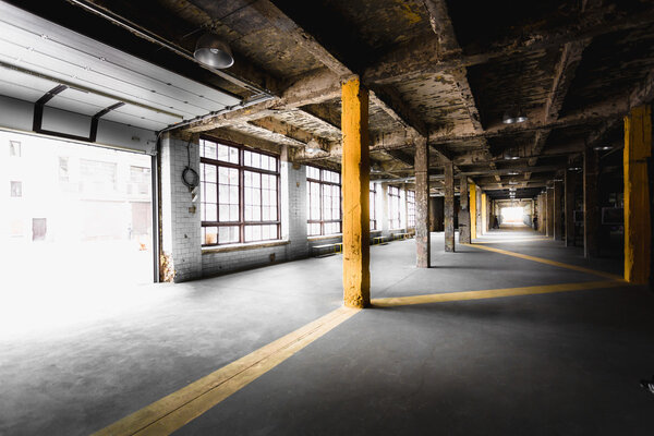 Interior of old abandoned factory hallway with big windows