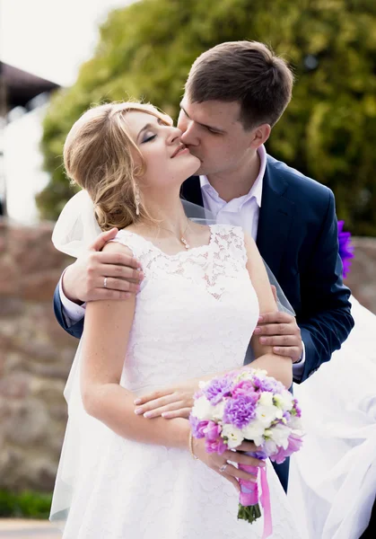 Schöner Bräutigam gibt einen Kuss auf die Wange der Bräute — Stockfoto