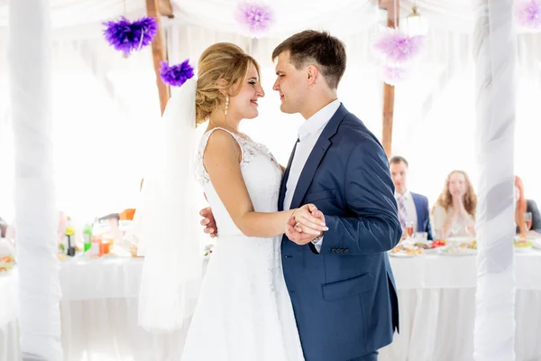 Mooie lachende bruid en bruidegom dansen in restaurant hal — Stockfoto