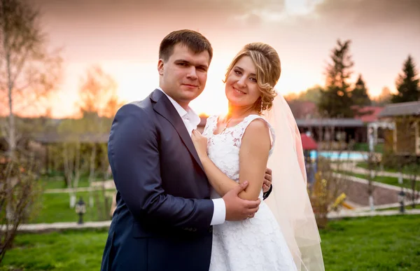 Retrato de novia feliz y novio abrazándose al atardecer en el parque —  Fotos de Stock