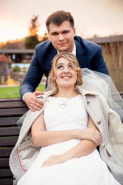 Retrato de novio guapo abrazando hermosa novia sentado en ser — Foto de Stock