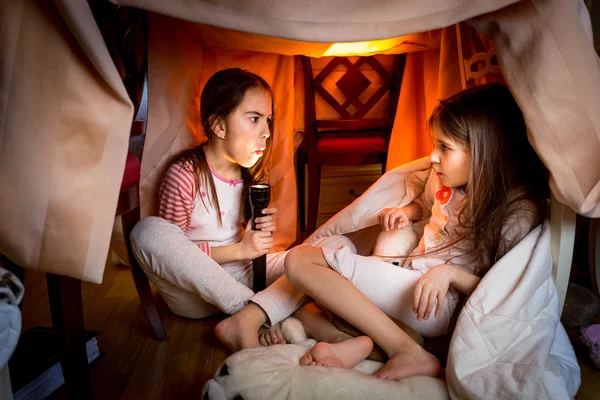 Elder sister telling scary story to younger one at late night — Stock Image Elder sister telling scary story to younger one at late night Stock Photo
