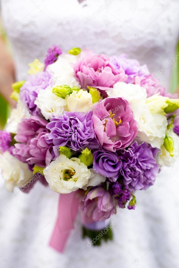 bride holding bridal bouquet with white, pink and purple flowers