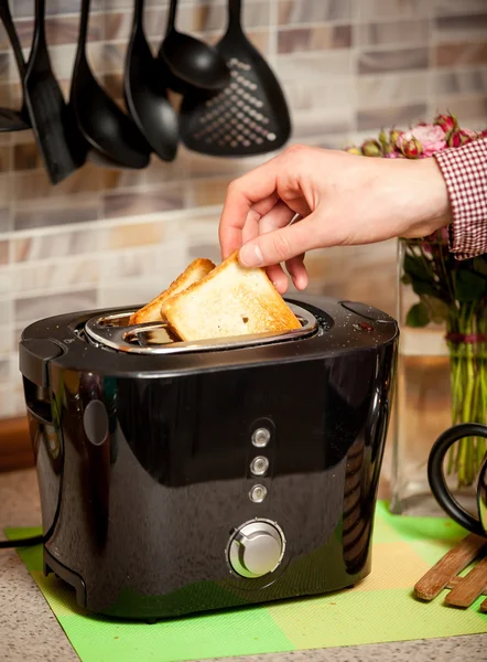 Nahaufnahme eines Mannes, der weiße Perlenscheiben in einen Toaster legt — Stockfoto