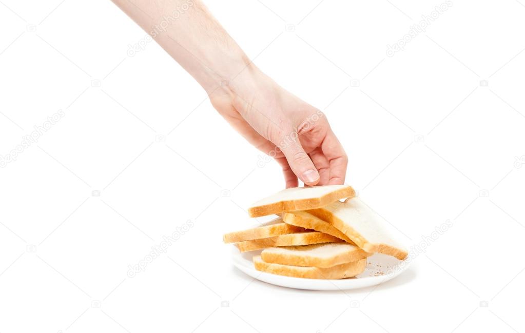 isolated shot of male hand taking piece of bread from plate