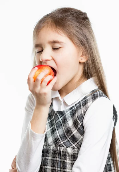 Isolated portrait of cute brunette schoolgirl biting red apple — Stock Photo, Image