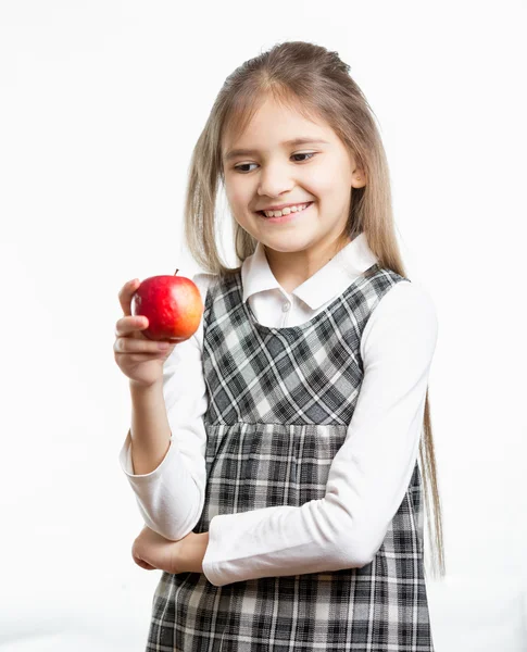 Isolated portrait of smiling schoolgirl looking at apple — Stock Photo, Image